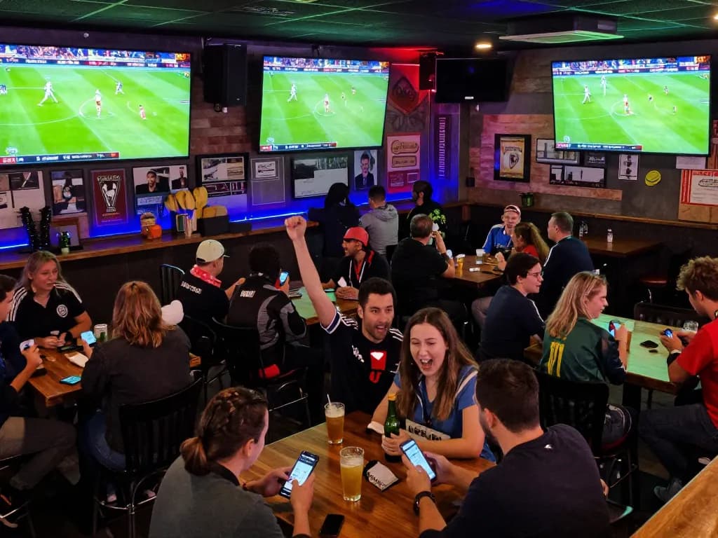 Cakhia TV live sports betting event with fans cheering in a vibrant bar atmosphere.